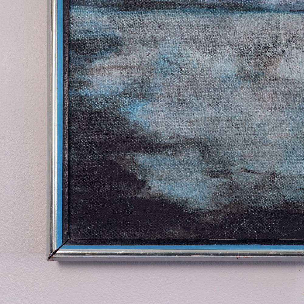 A close-up of a framed abstract painting featuring textured brushstrokes in shades of blue, gray, and black, mounted on a light pink wall.