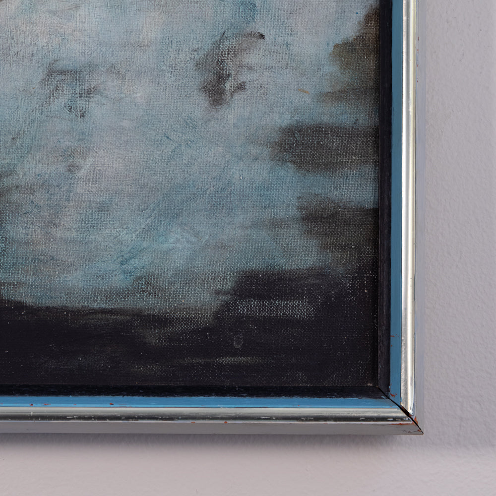 Close-up of a framed painting showing textured blue-gray and black brushstrokes, mounted on a light gray wall.