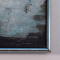 Close-up of a framed painting showing textured blue-gray and black brushstrokes, mounted on a light gray wall.