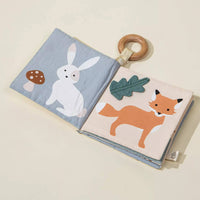 Open book with animal illustrations and a wooden ring on a beige background