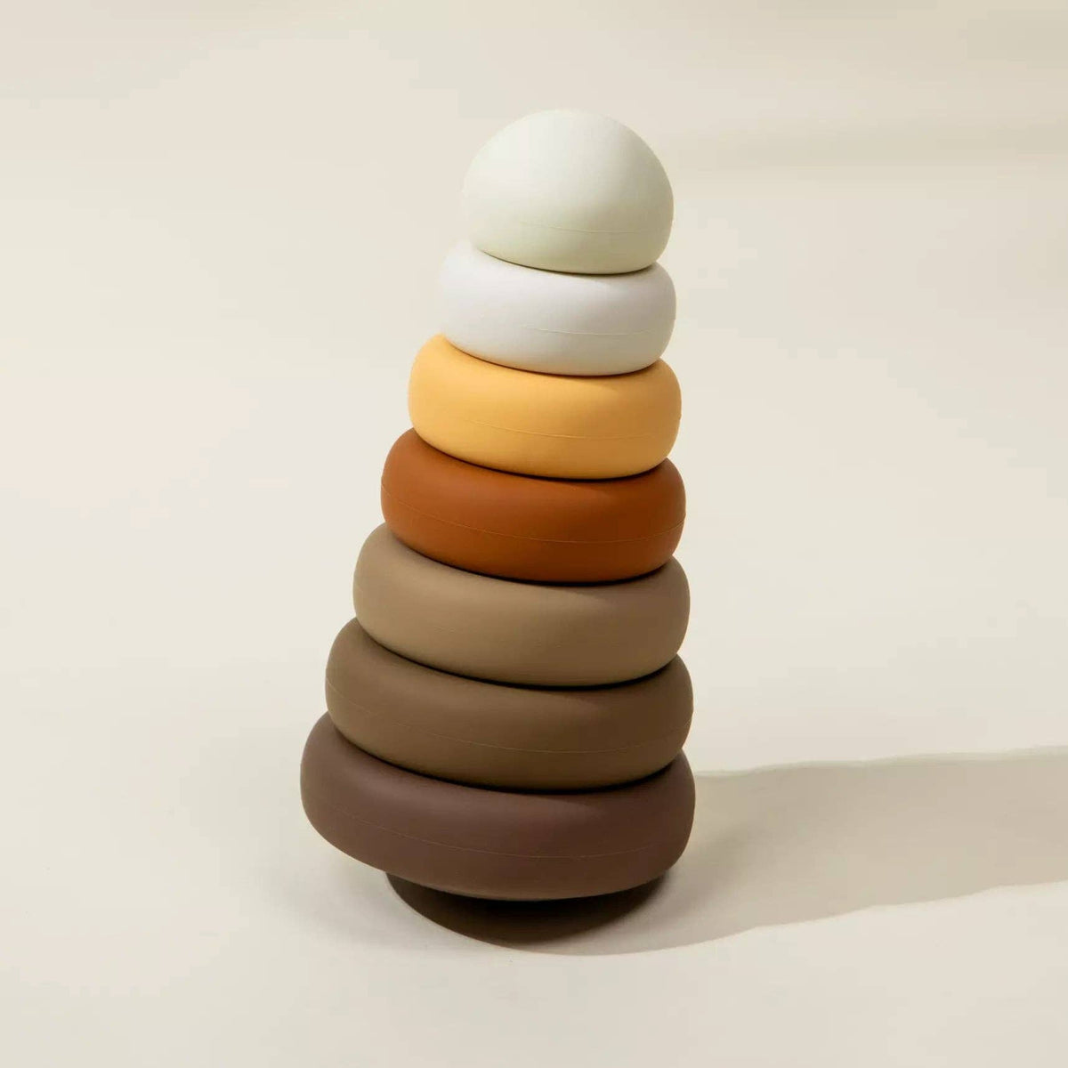 Stack of colorful wooden rings on a beige background
