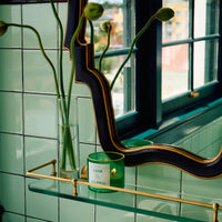 NUEVE LEONES Candle  green on a glass shelf
