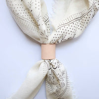 Beige scarf with black patterns on a white background