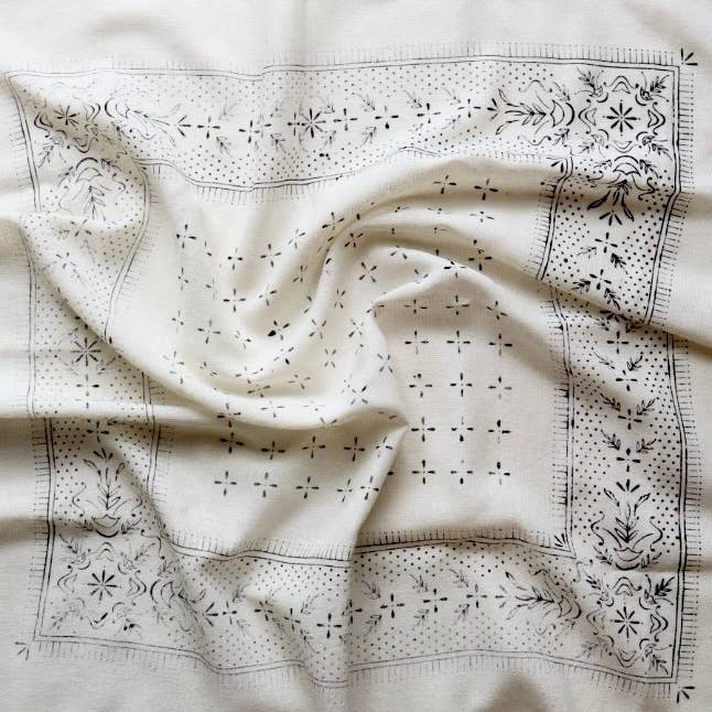 White fabric with black embroidery patterns on a white background
