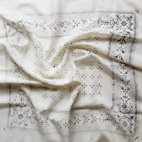 White fabric with black embroidery patterns on a white background
