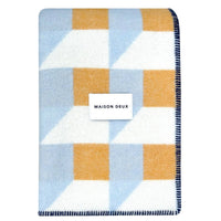 Checkered blanket with geometric pattern and 'Maison Deux' label on a white background