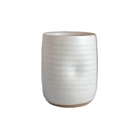 A small cylindrical ceramic cup or candle holder with a textured, ribbed surface and a matte off-white finish, shown against a plain white background.