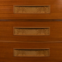 Close-up of a wooden chest of drawers showing three drawers with rectangular glass-front fronts and decorative inlay.