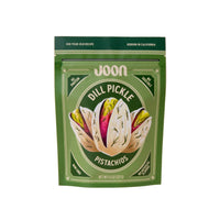 Green package of JOON Dill Pickle Pistachios on a beige background