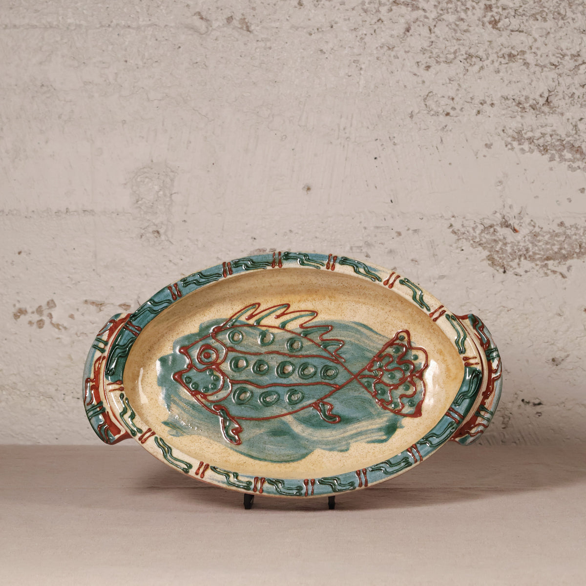 Ceramic platter with fish design on a textured surface