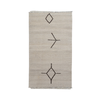 A rectangular natural beige woven rug with a minimalist black geometric pattern of diamonds and lines, featuring short fringe on the top and bottom edges.