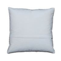 A square white throw pillow with a stitched hem and decorative bead trim along the edges, displayed flat on a gray wooden plank surface.