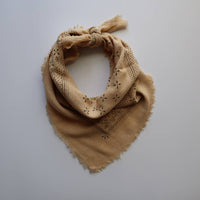 Beige patterned scarf on a light gray background