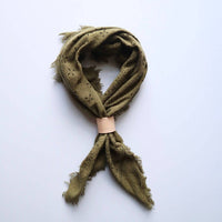 Green scarf with a wooden ring on a white background