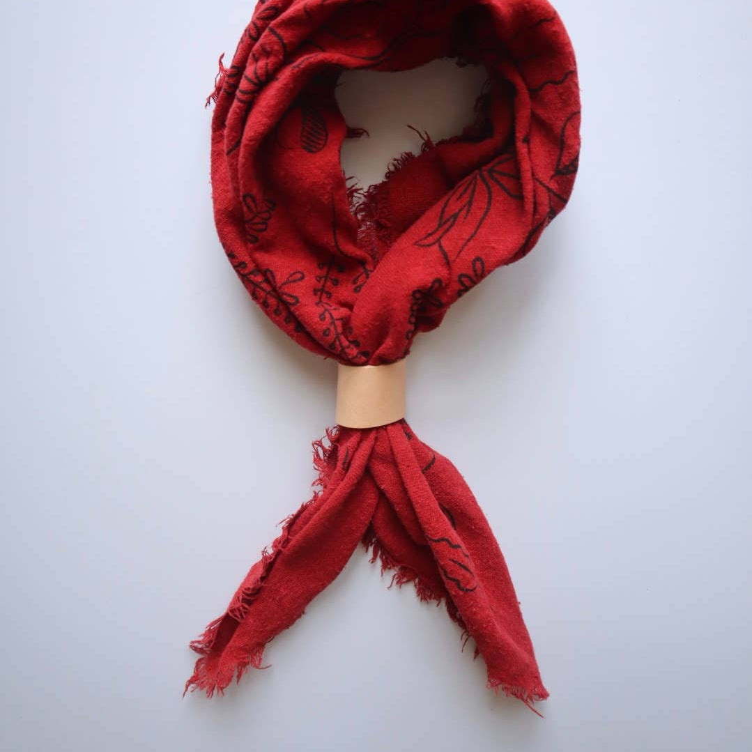 Red scarf with black patterns on a white background