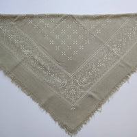 Green triangular scarf with embroidered pattern on a white background
