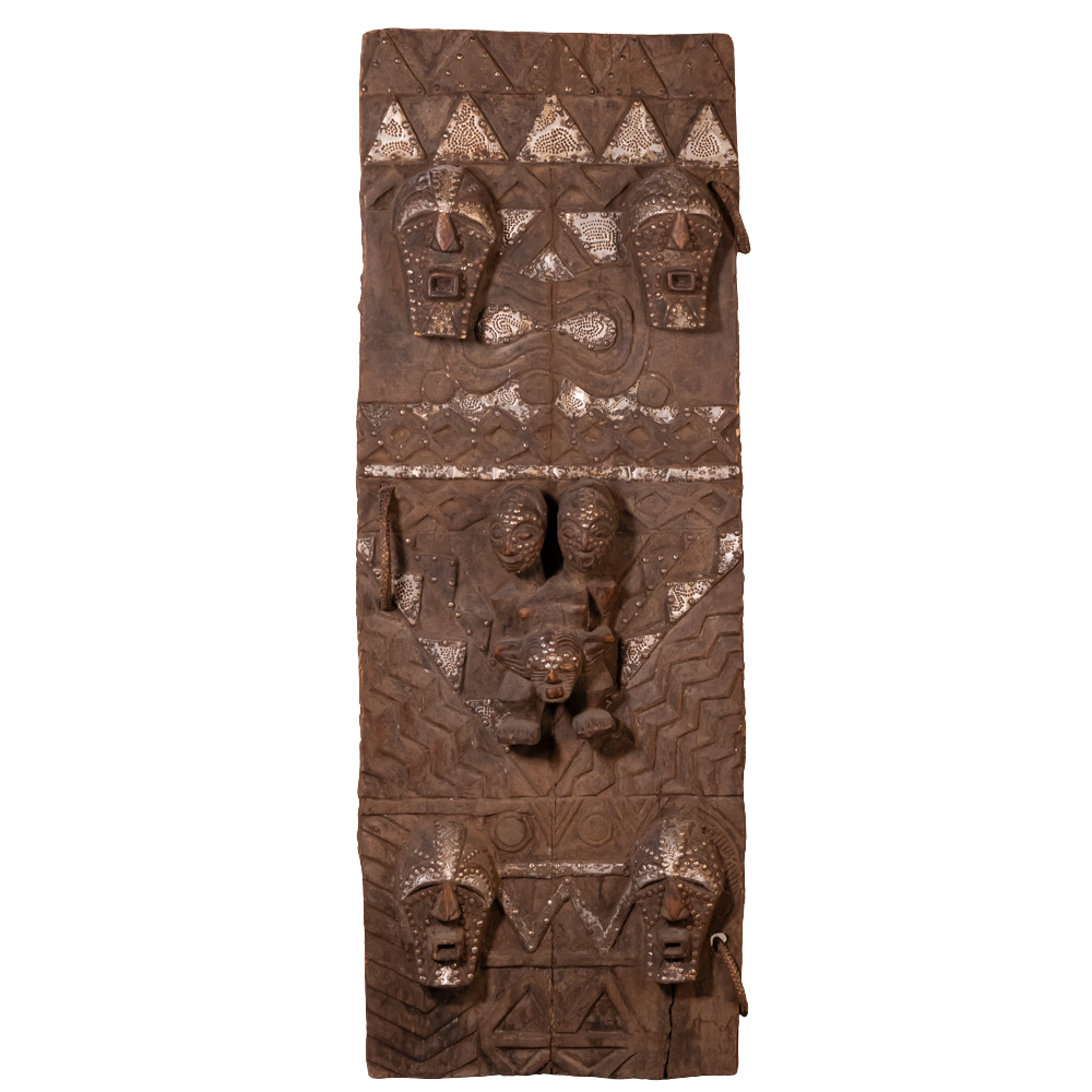A tall, narrow carved wooden wall art piece with intricate tribal-style relief carvings and geometric patterns, shown against a plain white background.