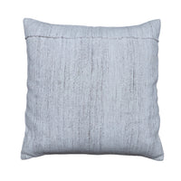 A square throw pillow in a textured light gray linen-like fabric, displayed flat on a rustic gray wooden plank surface.