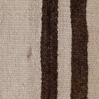 Close-up of a woven textile with a warm off-white background and two vertical dark brown stripes.