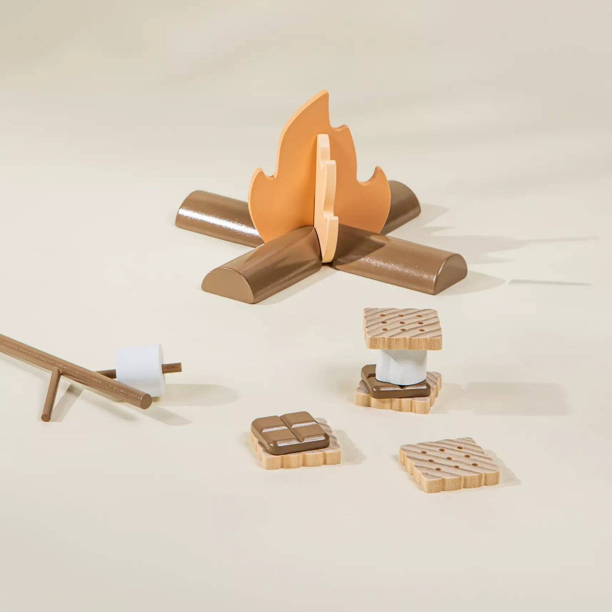 Wooden toy campfire with logs and a cooking stick on a beige background