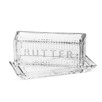 Clear glass butter dish with 'BUTTER' engraving on a white background
