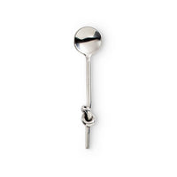 A polished silver-toned metal spoon with a decorative knot detail on its handle, shown against a plain white background.
