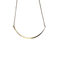 Gold necklace on a textured stone surface