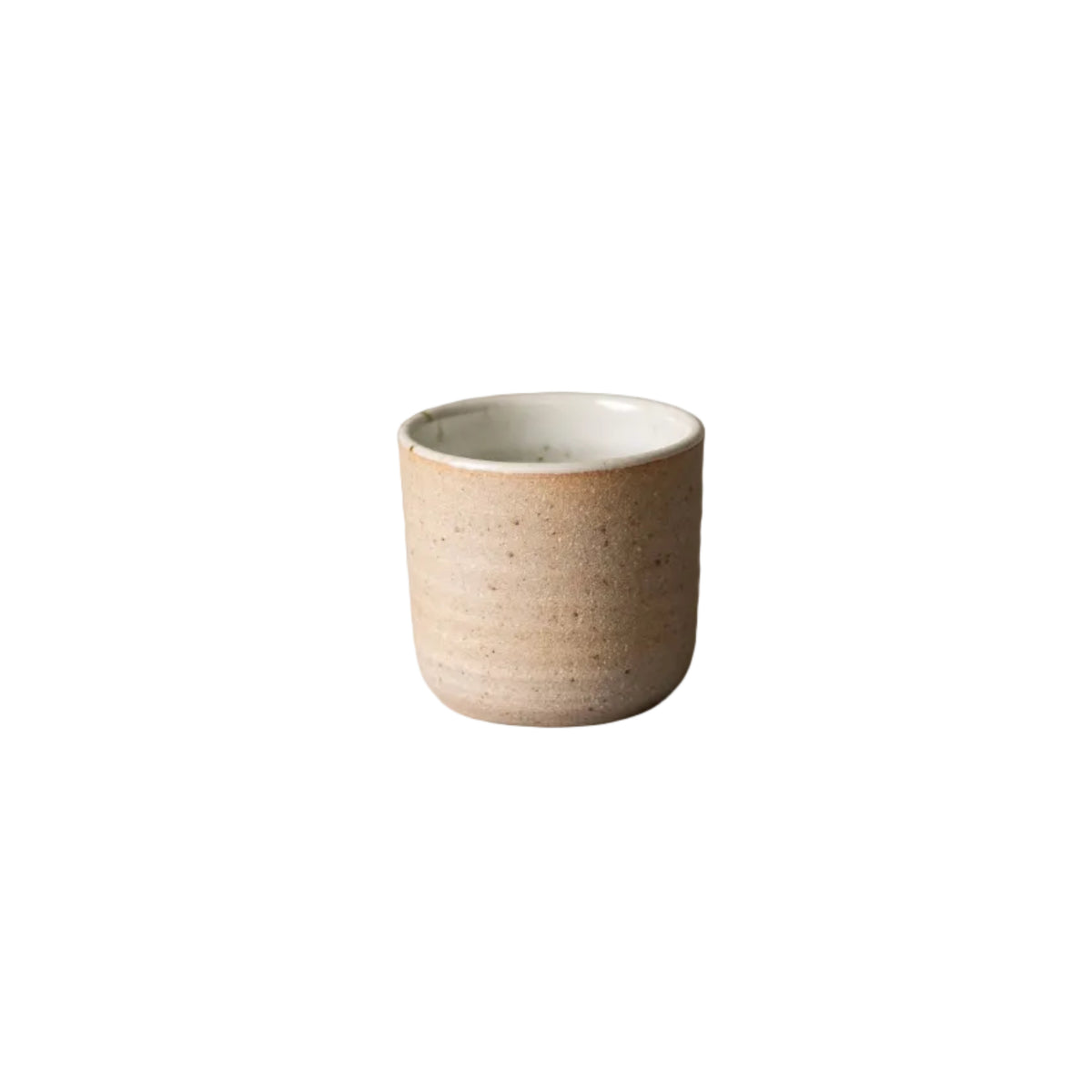 Beige ceramic cup on a gray surface with a neutral background