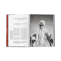 An open book spread showing a black-and-white photograph on the right page and text on the left page, photographed against a plain white background.