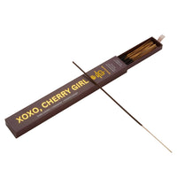 Incense stick with packaging labeled 'XOXO, Cherry Girl' on a beige background