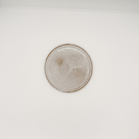 Round ceramic plate with textured edge on a white background